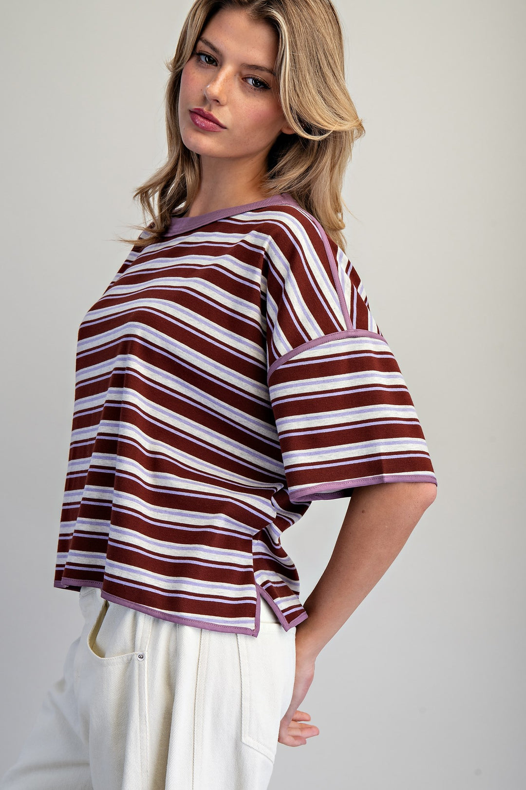 Woman wearing a striped shirt with a plain background