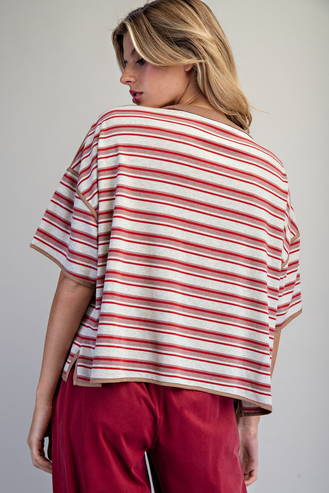 Woman wearing a red and white striped shirt with a plain background