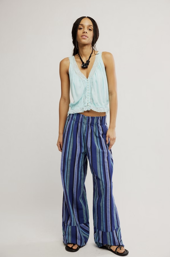 Woman wearing blue stripe pants and blue top on white background