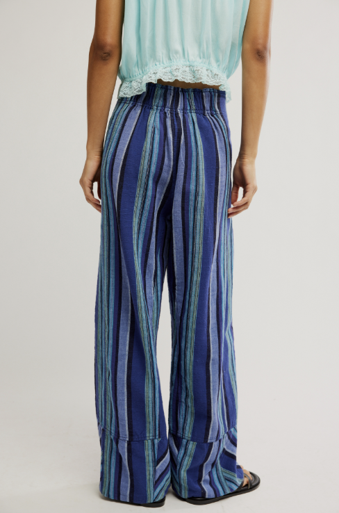 Person wearing blue striped pants on a plain background