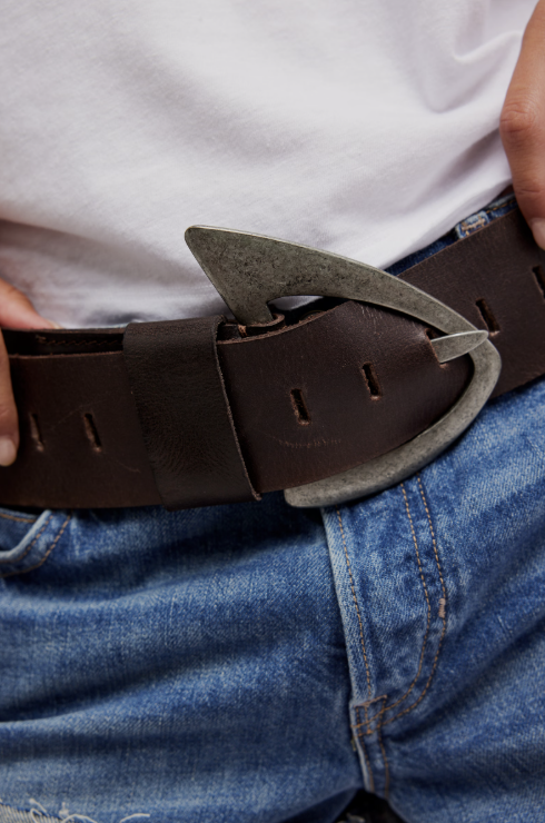 Close-up of a person wearing a brown belt with a unique buckle.