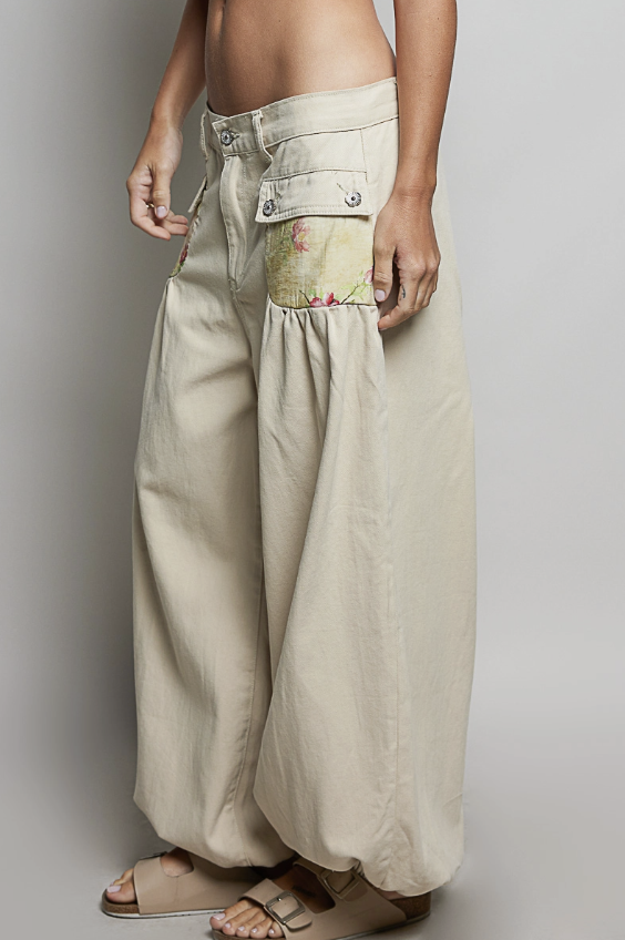 Woman wearing beige balloon pants on plain background