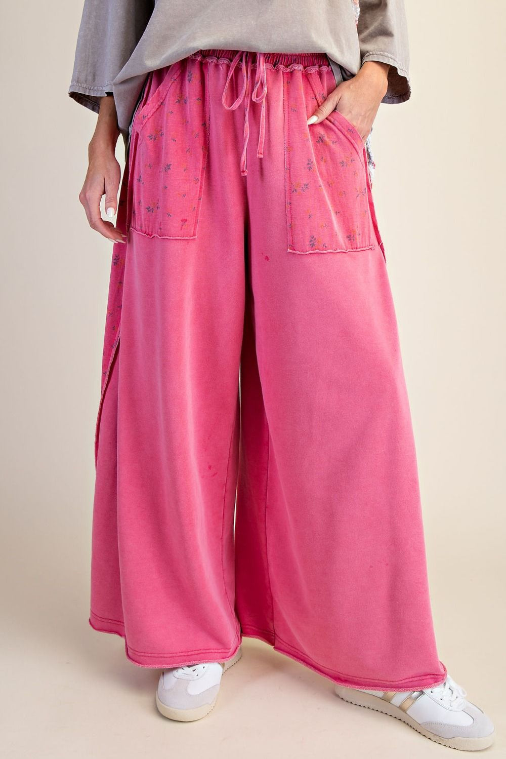 Person wearing pink wide-leg pants with a neutral background