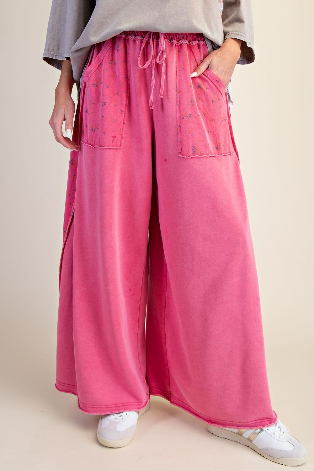 Person wearing pink wide-leg pants with a neutral background