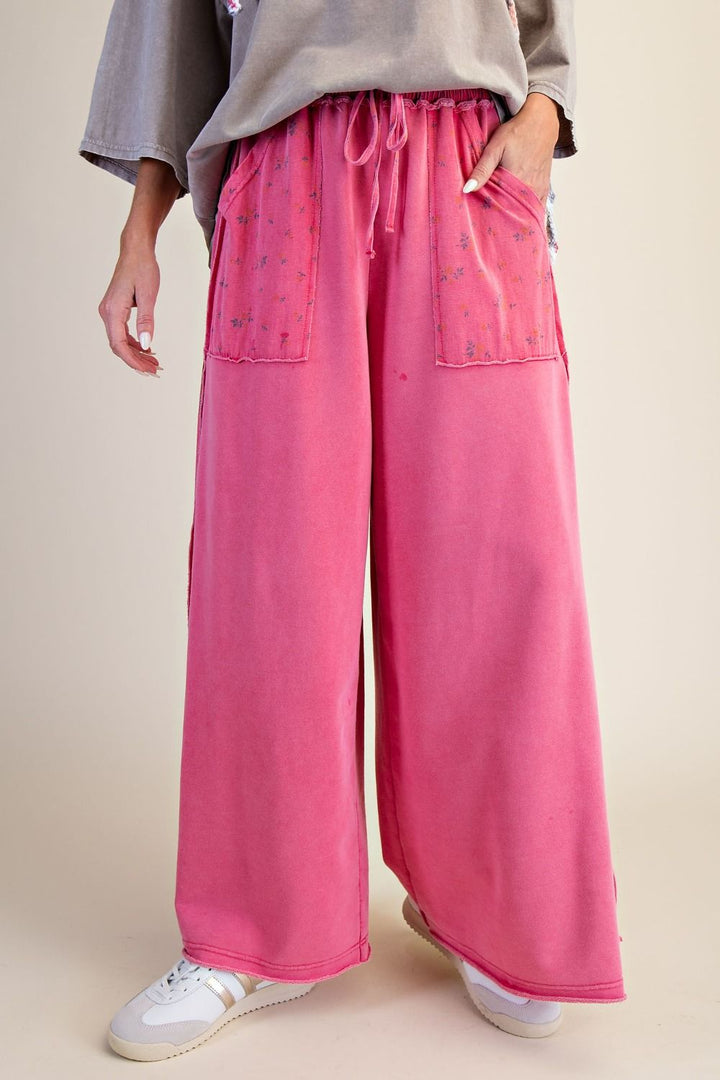 Person wearing pink wide-leg pants with a neutral background
