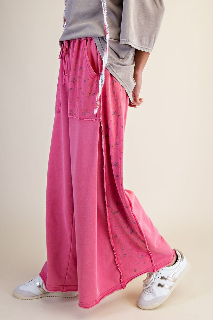 Person wearing bright pink wide-leg pants with a neutral background