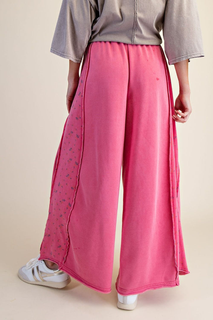 Person wearing pink wide-leg pants with a neutral background