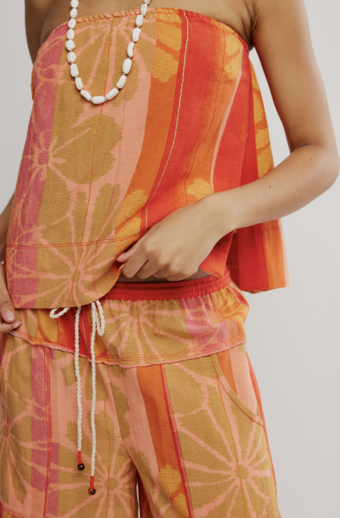 Person wearing a colorful patterned outfit with a plain background