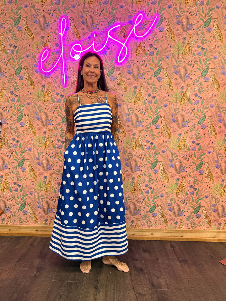 Woman wearing polka dot and stripe blue maxi on pink floral background