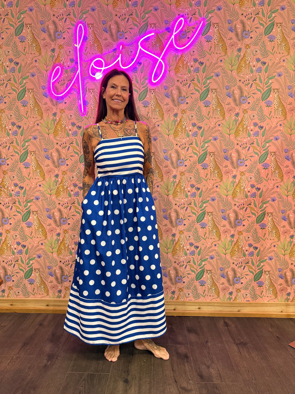 Woman wearing polka dot and stripe blue maxi on pink floral background