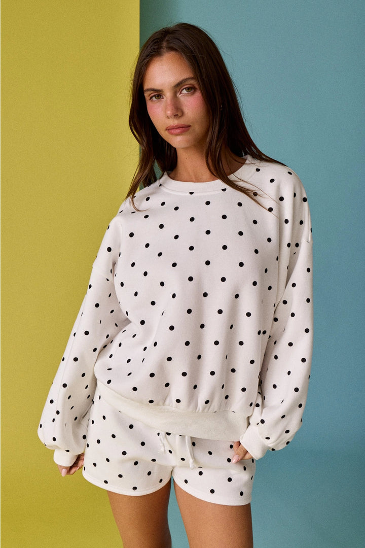 Woman wearing polka dot matching set on yellow and blue background