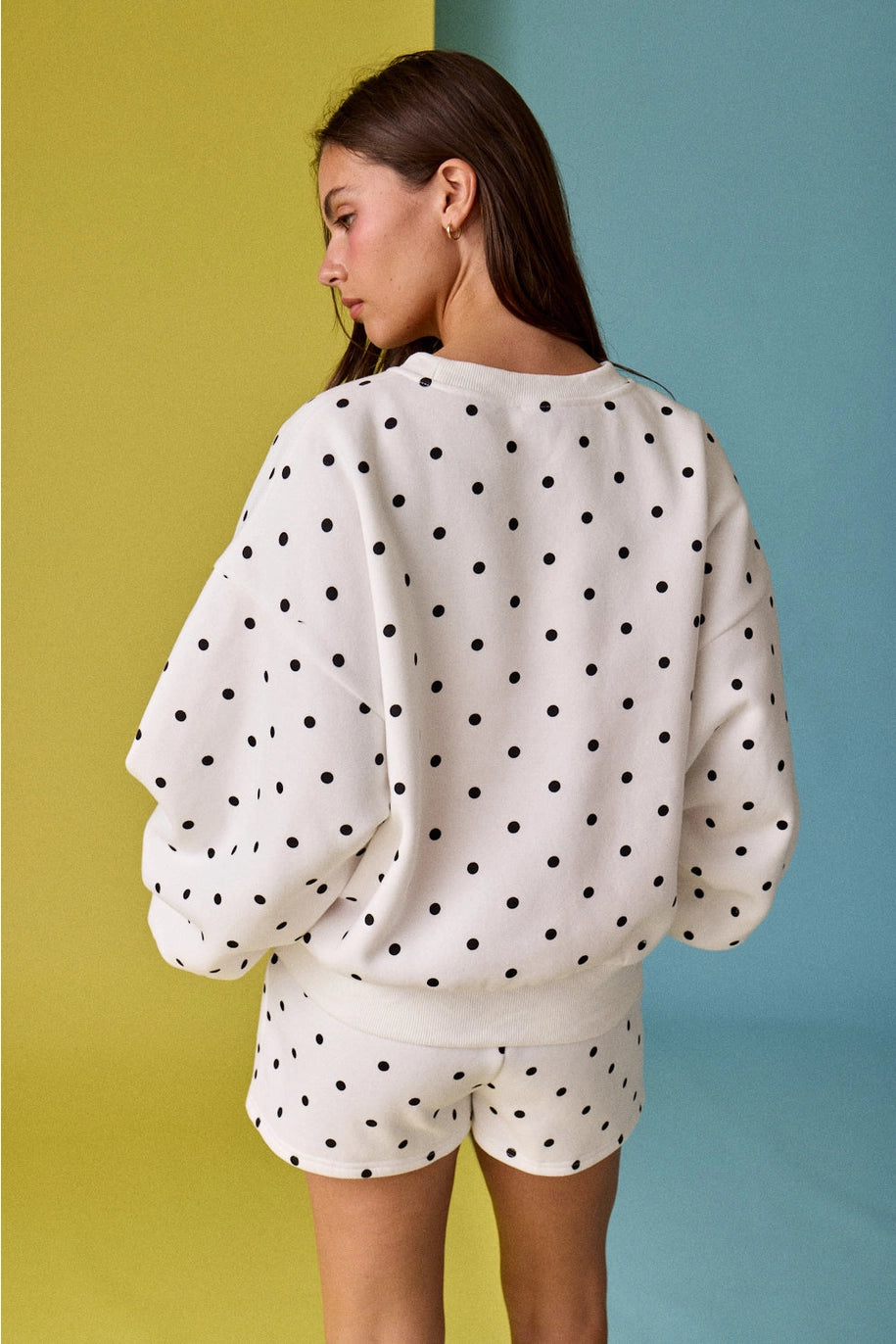 Person wearing a polka dot outfit against a colorful background