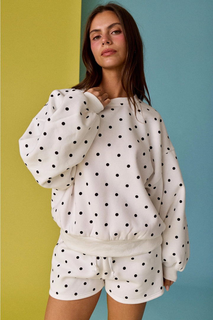 Woman wearing a polka dot outfit against a colorful background