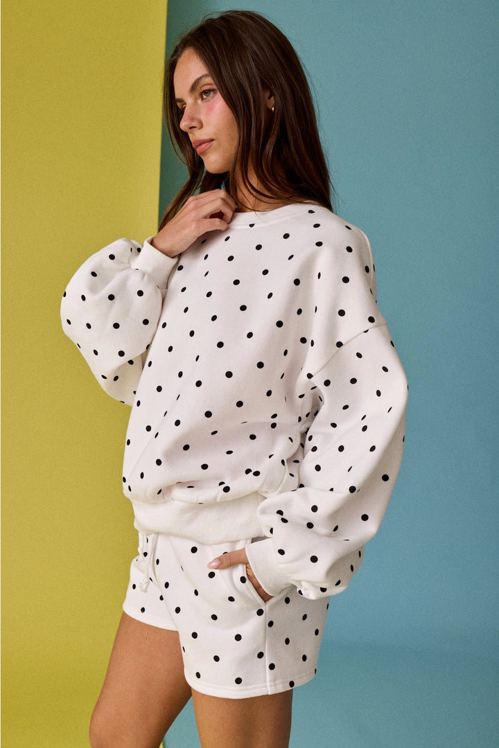 Woman wearing a polka dot outfit against a colorful background