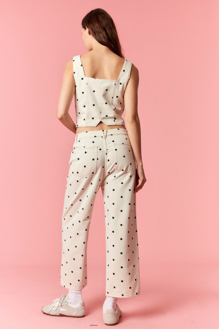 Woman wearing a polka dot outfit on a pink background