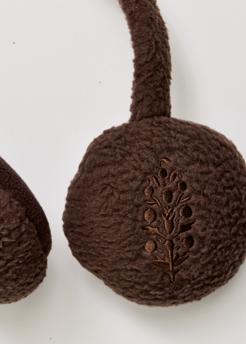 Close up of brown plush fleece ear warmers on plain background with logo