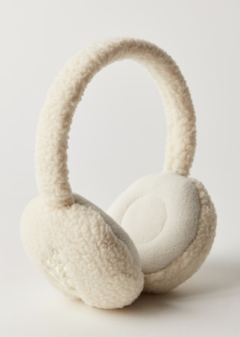 Pair of cream plush fleece ear warmers on plain background