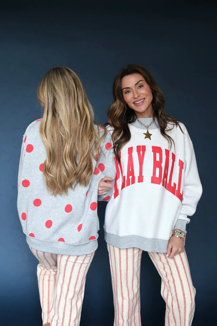 Two women wearing a reversible sweatshirt with &