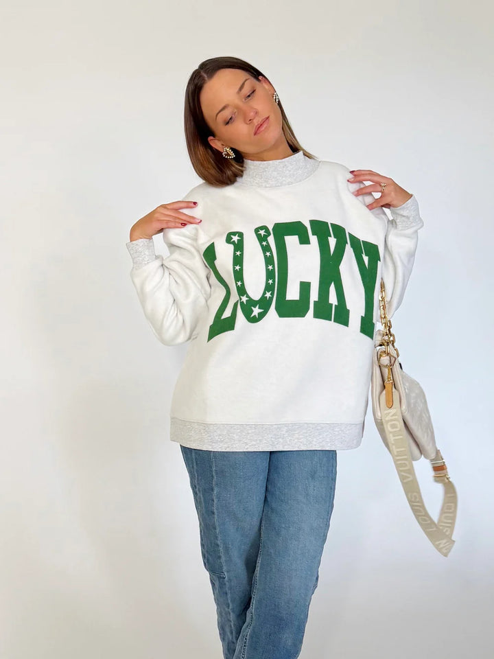 Person wearing a white sweatshirt with &