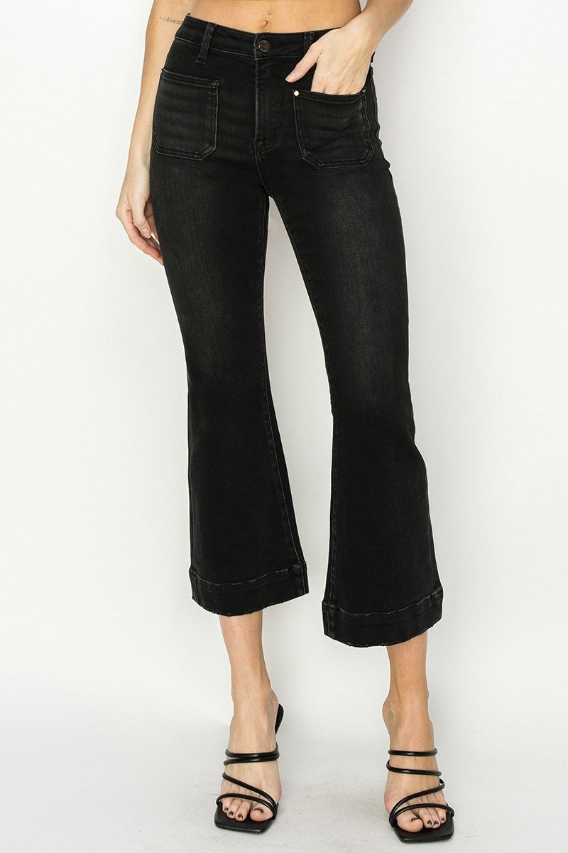 Person wearing black cropped jeans on a white background