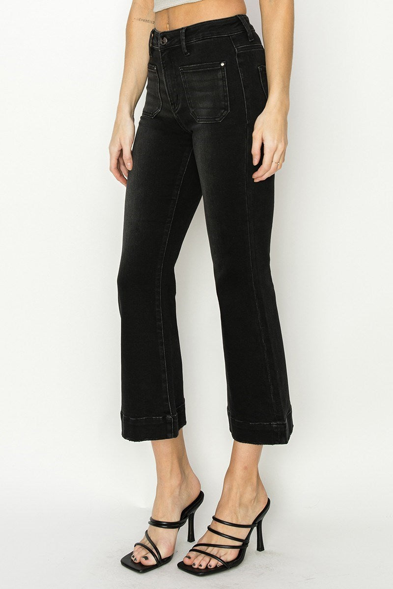 Person wearing black high-waisted jeans on a white background