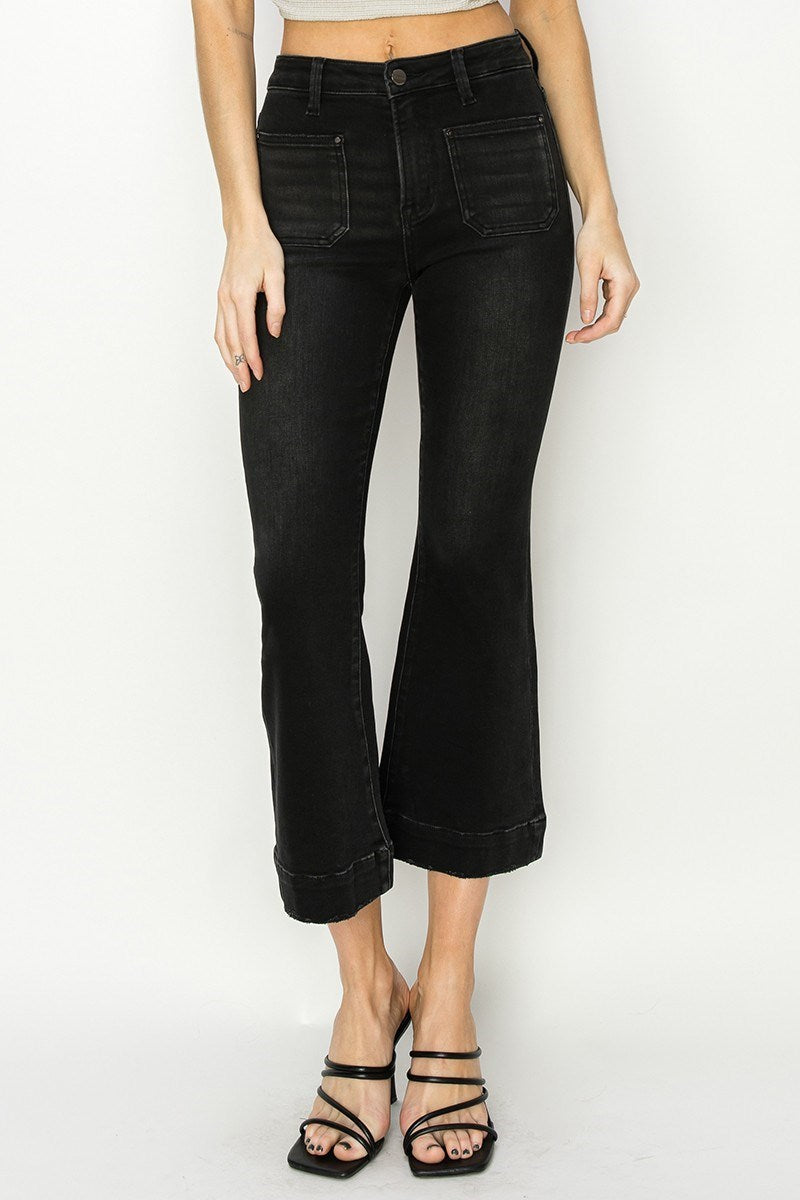 Person wearing black wide-leg jeans on a white background