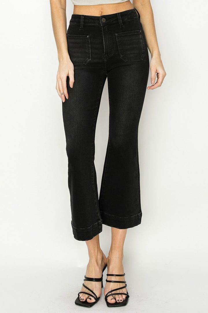 Person wearing black wide-leg jeans on a white background