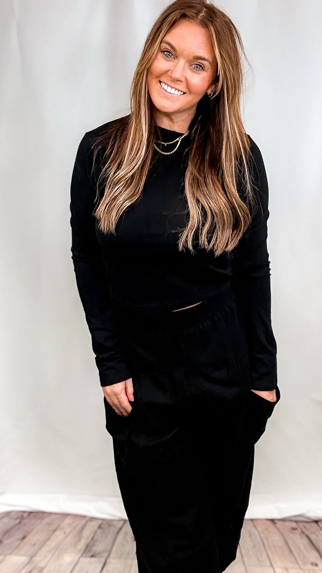 Woman wearing matching black set on plain background
