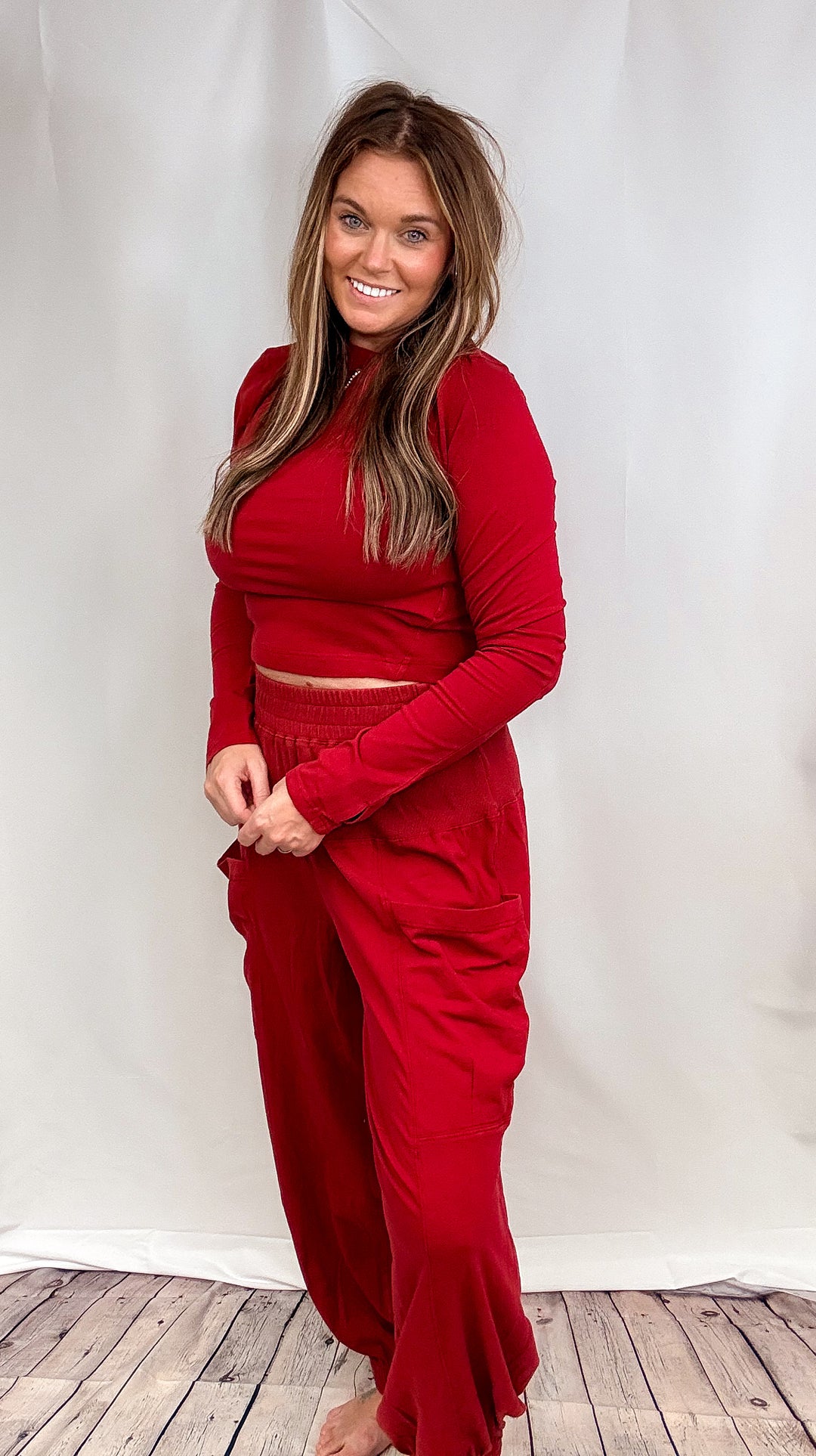 Woman wearing matching red lounge set on plain background