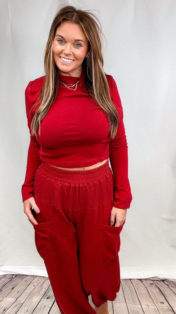 Woman wearing matching red lounge set on plain background