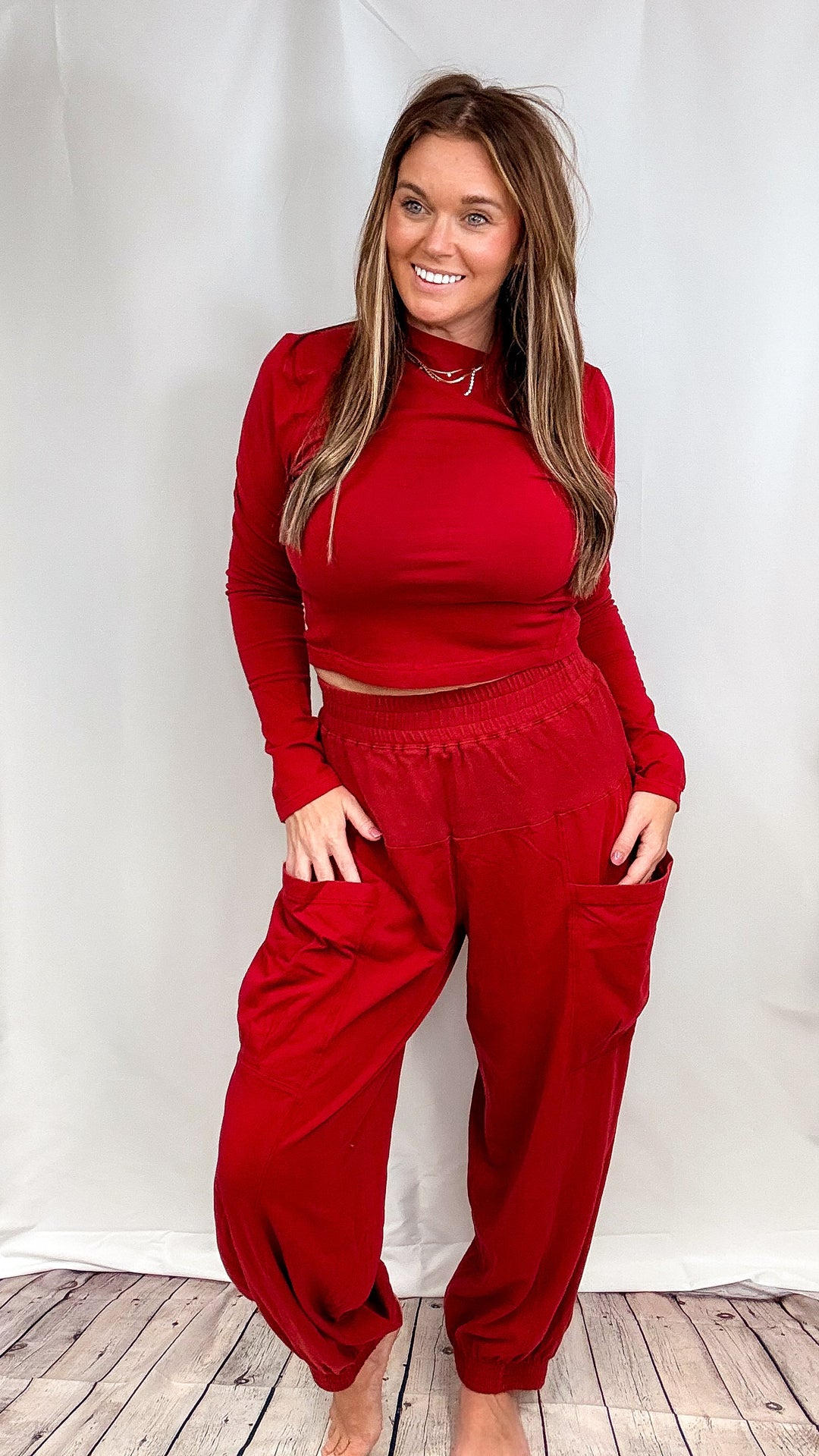 Woman wearing matching red lounge set on plain background