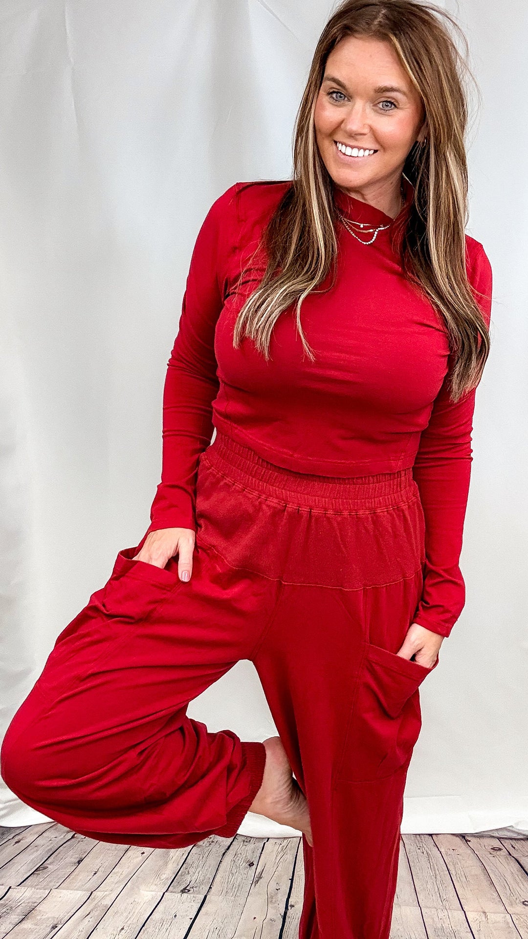 Woman wearing matching red lounge set on plain background