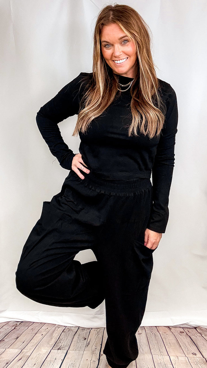 Woman wearing matching black lounge set on plain background