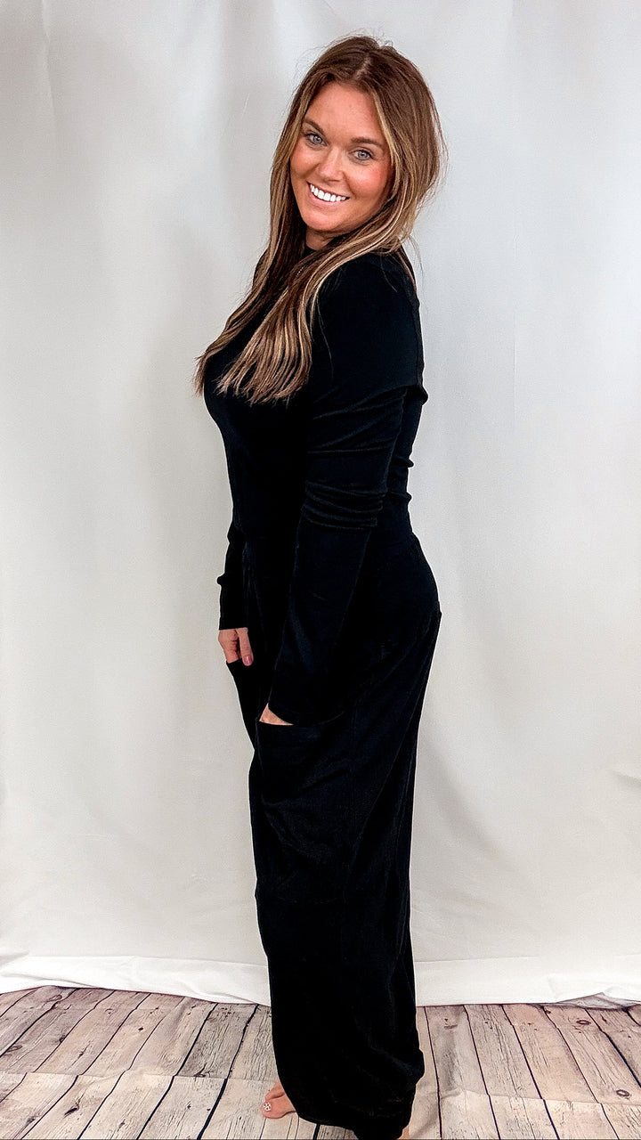 Woman wearing matching black lounge set on plain background