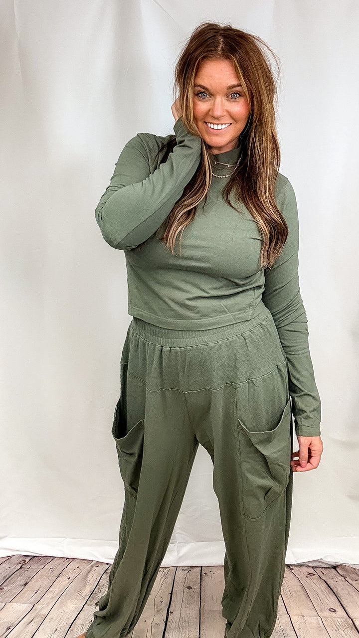 Woman wearing matching green lounge set on plain background