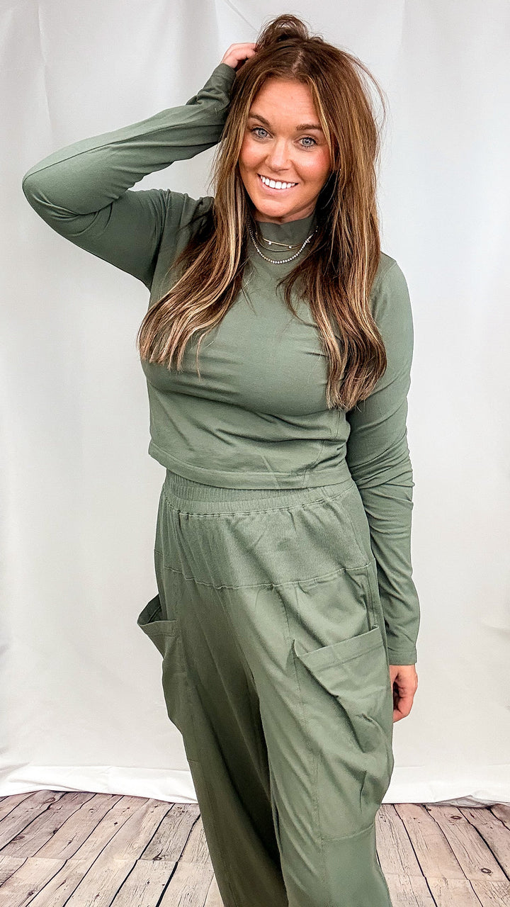 Woman wearing matching green lounge set on plain background
