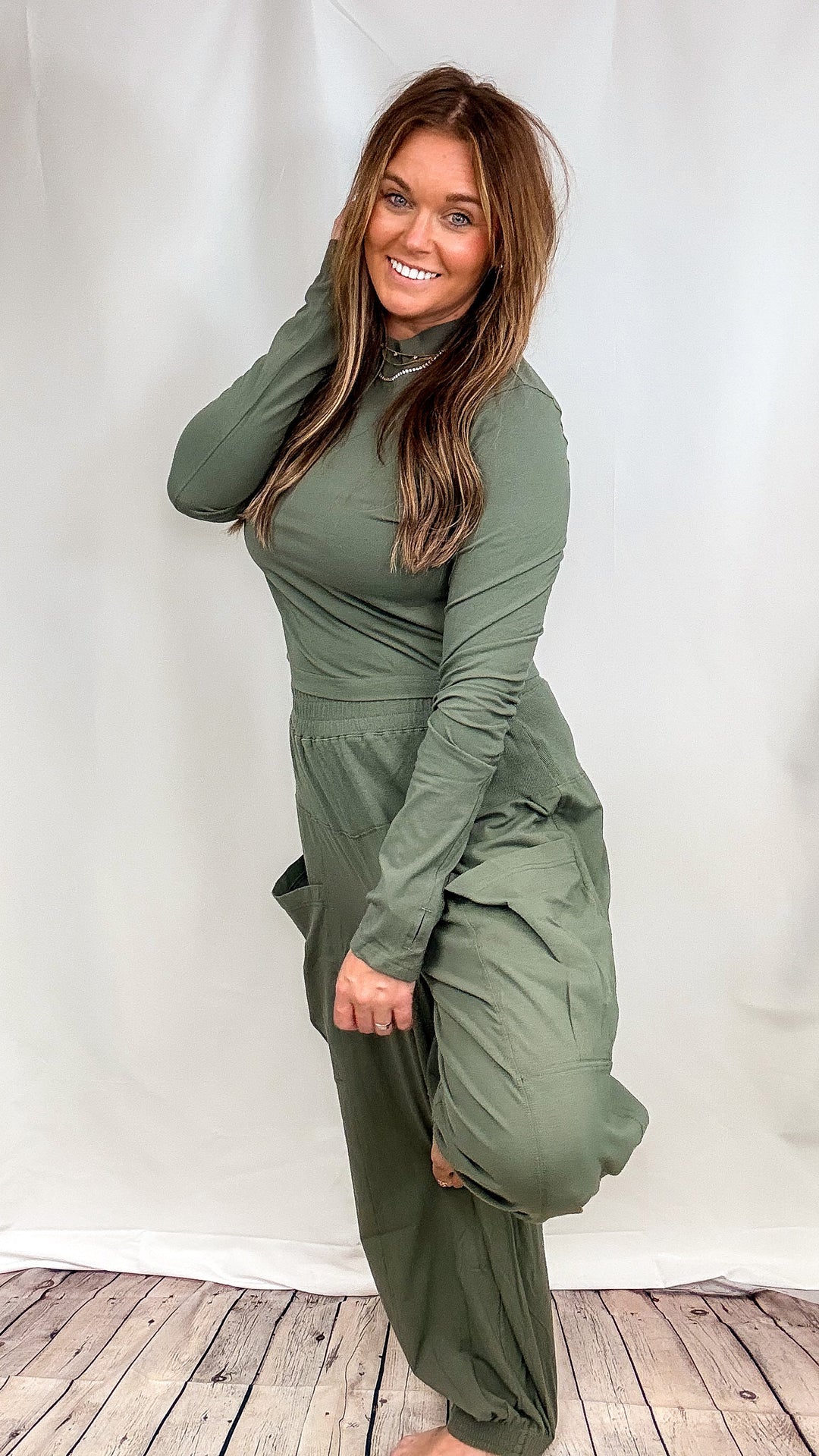 Woman wearing matching green lounge set on plain background