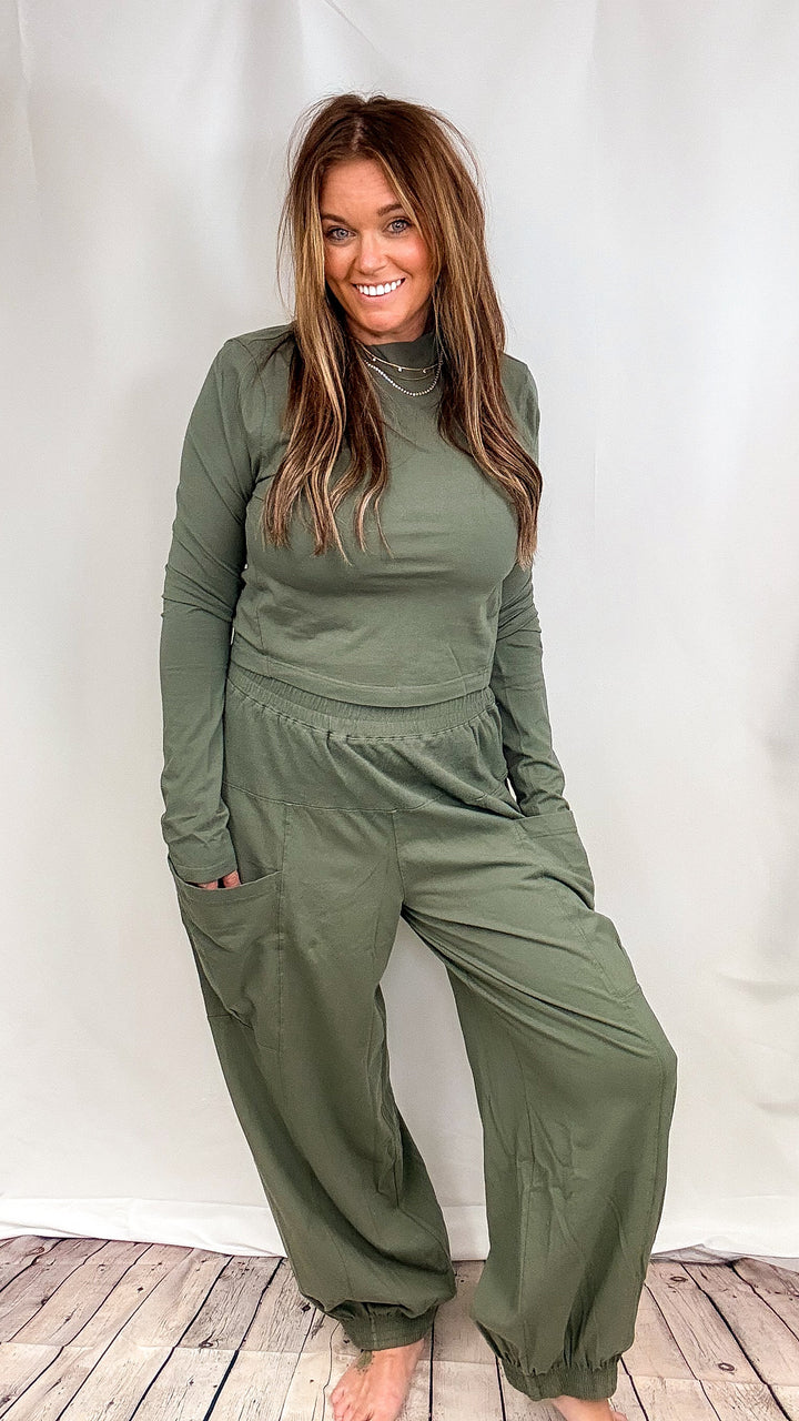 Woman wearing matching green lounge set on plain background