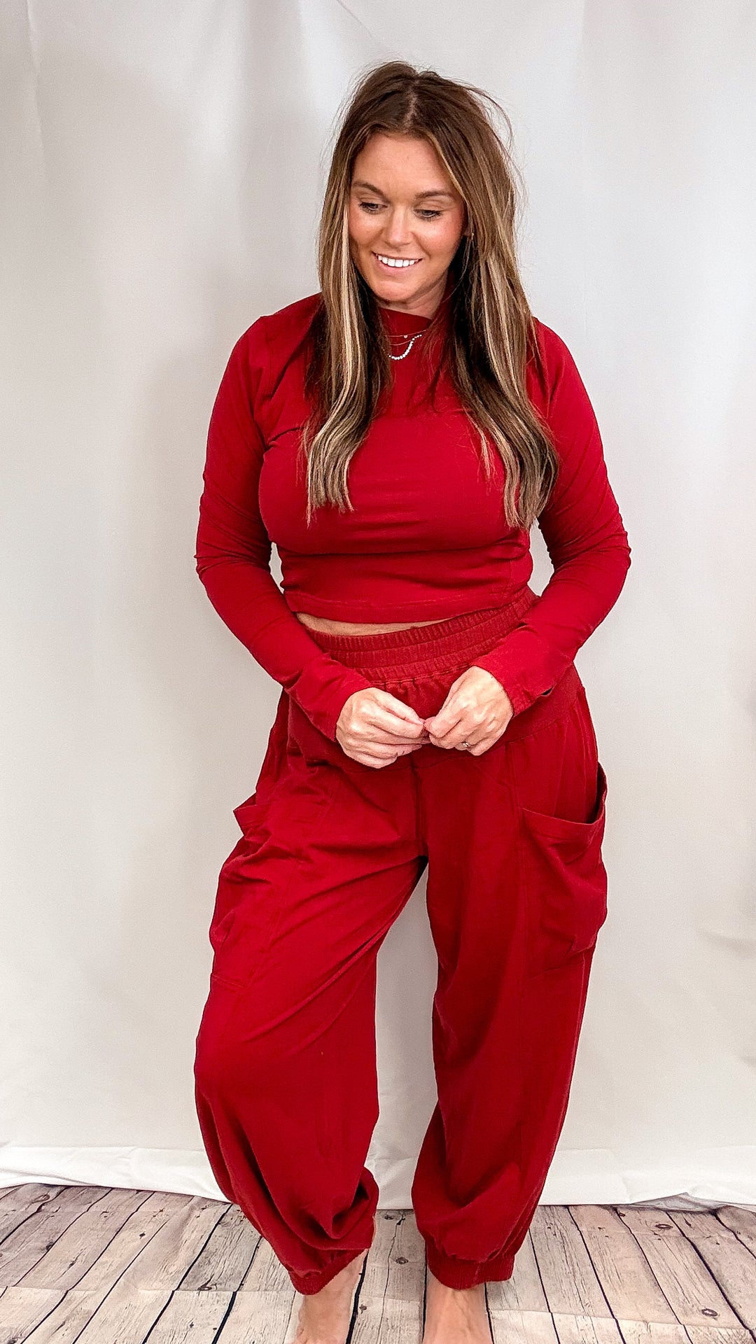 Woman wearing matching red lounge set on plain background