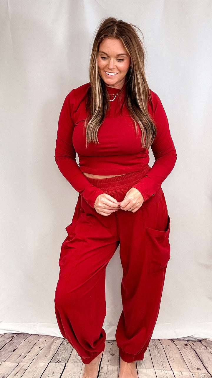 Woman wearing matching red lounge set on plain background