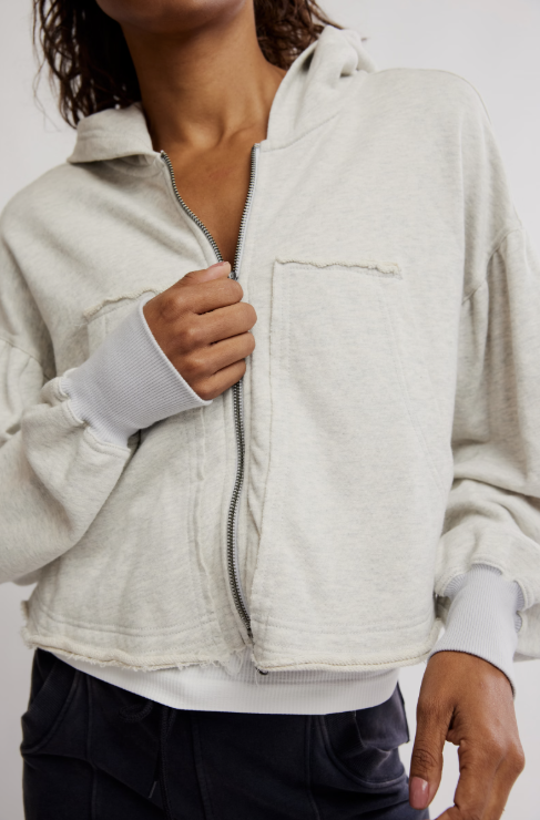 Person wearing a light gray fleece jacket with a neutral background