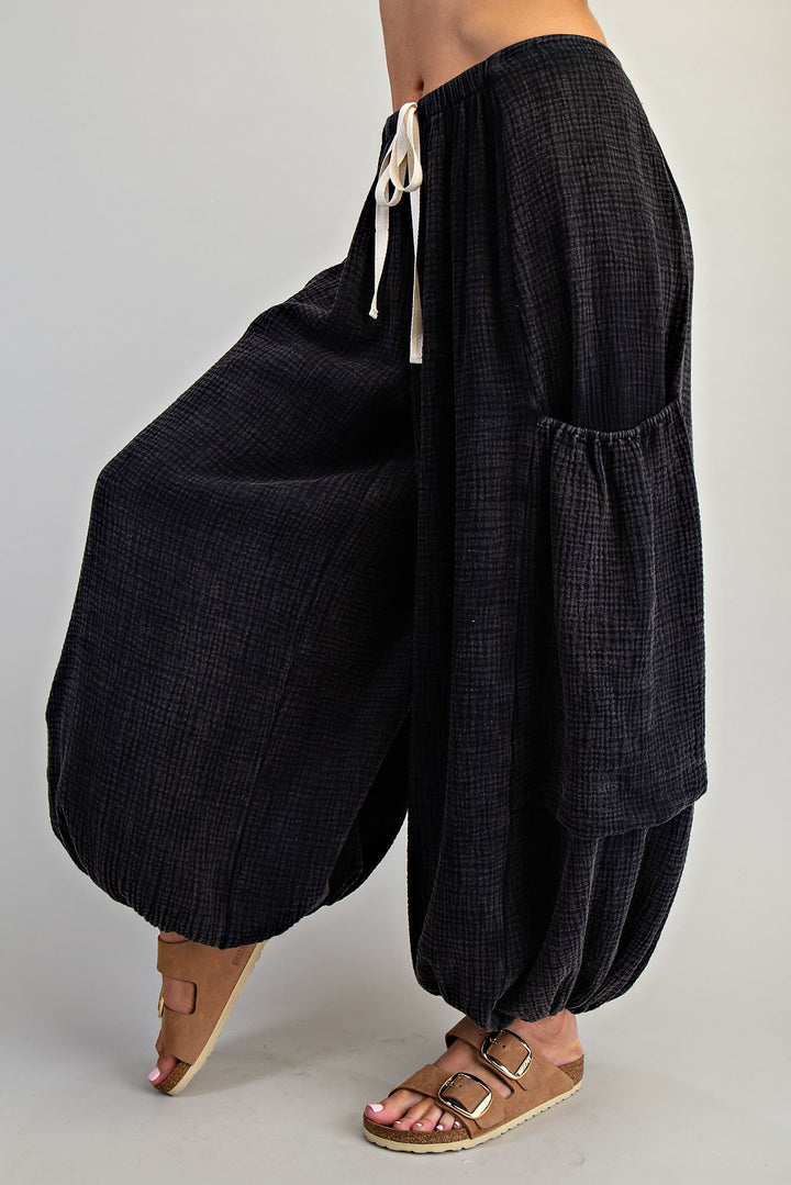 Black wide-leg pants with a drawstring waist on a plain background