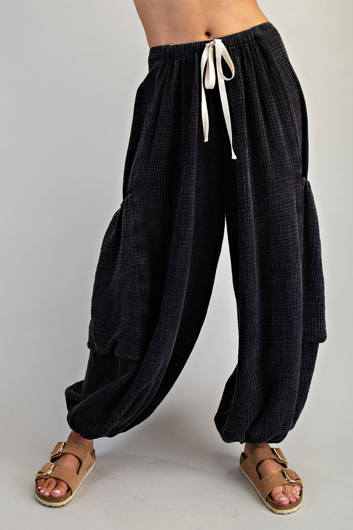 Black wide-leg pants with a white drawstring on a plain background