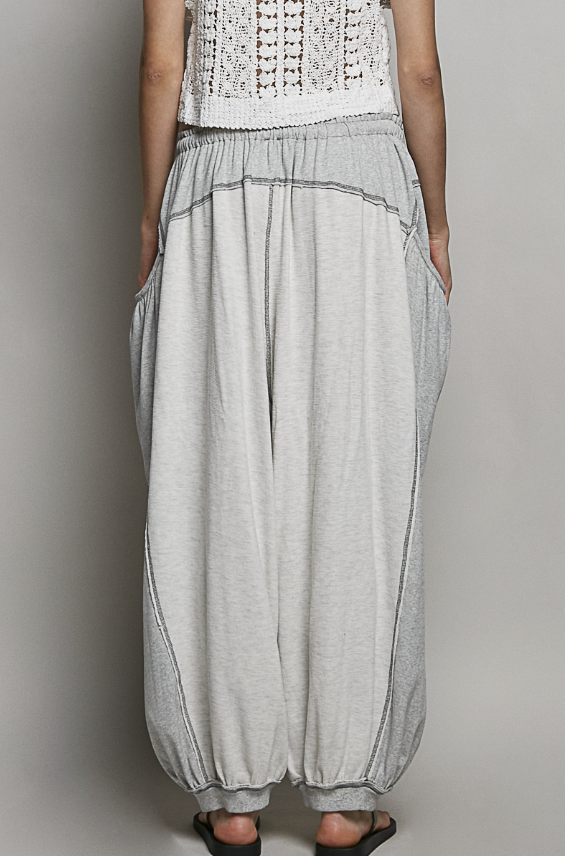 Person wearing light gray wide-leg pants on a plain background