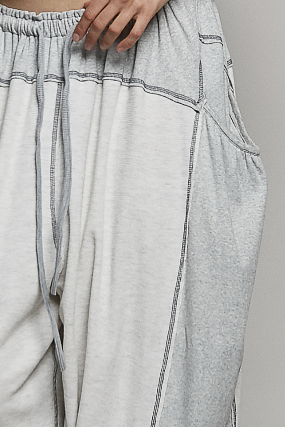 Gray wide-leg pants with drawstring waistband on a plain background