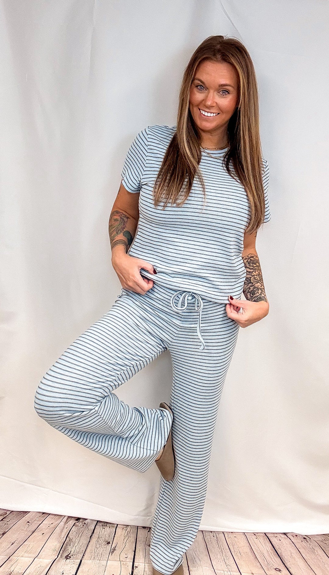 Woman wearing matching blue stripe set on plain background