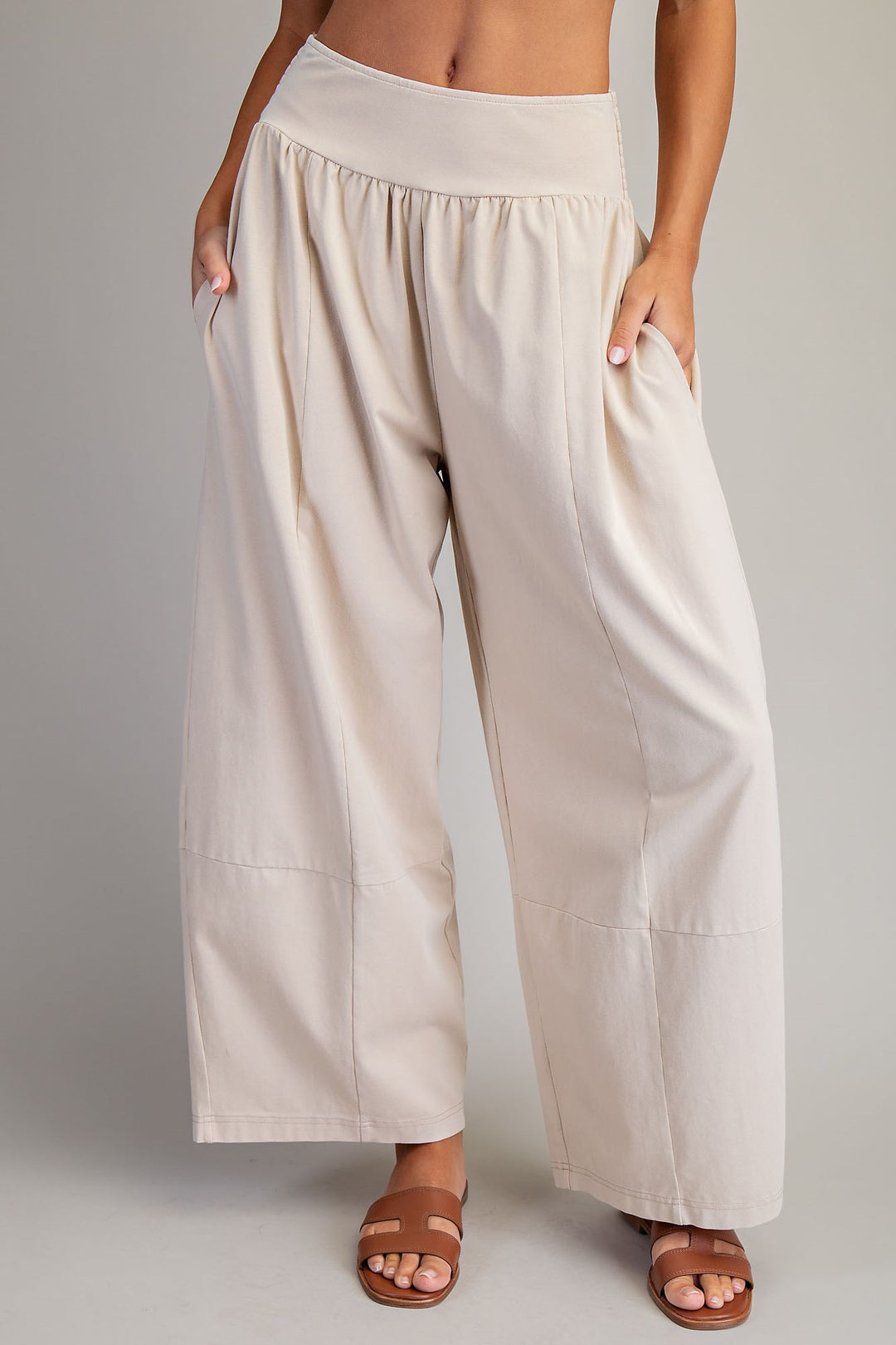 Woman wearing beige pants on plain background