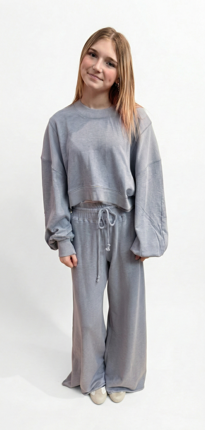 Person wearing a gray tracksuit on a white background