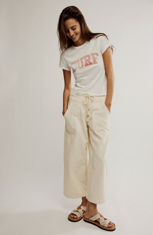 A woman modeling a white t-shirt with a coral-pink &
