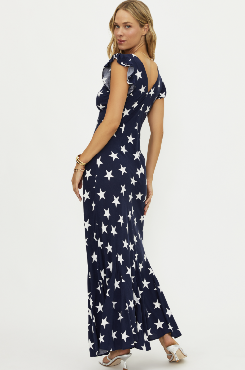 Woman wearing navy maxi dress with white star pattern on white background